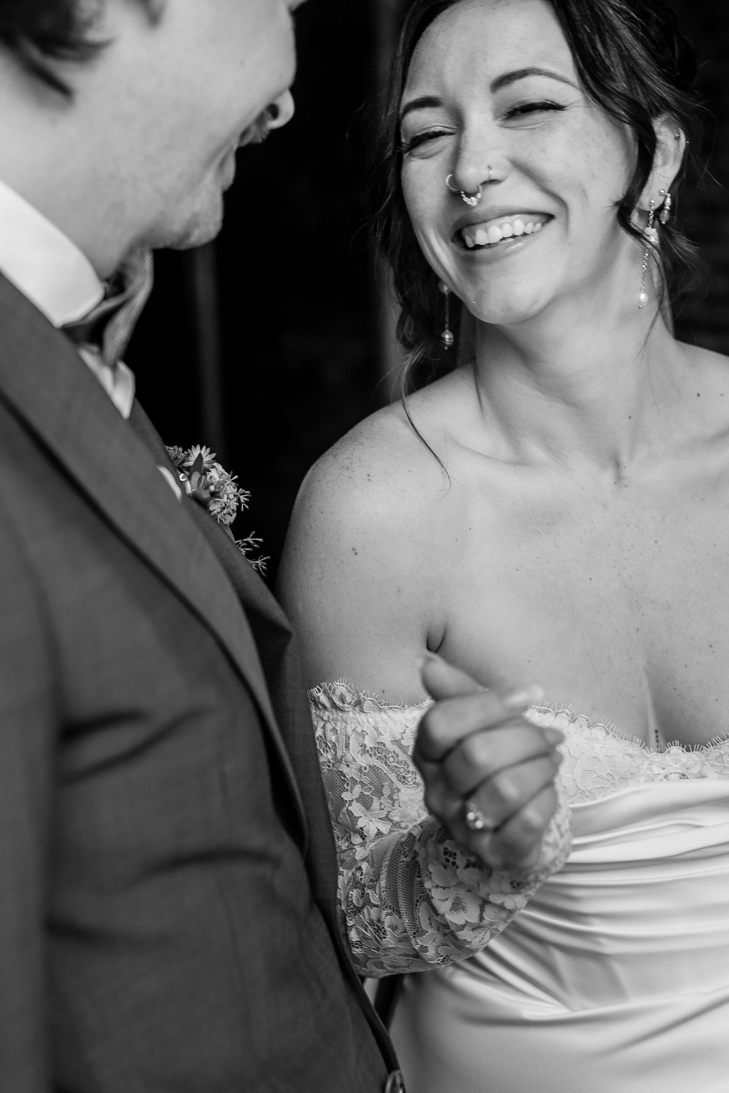 A joyful black and white wedding moment captures a couple sharing a laugh during their special day.