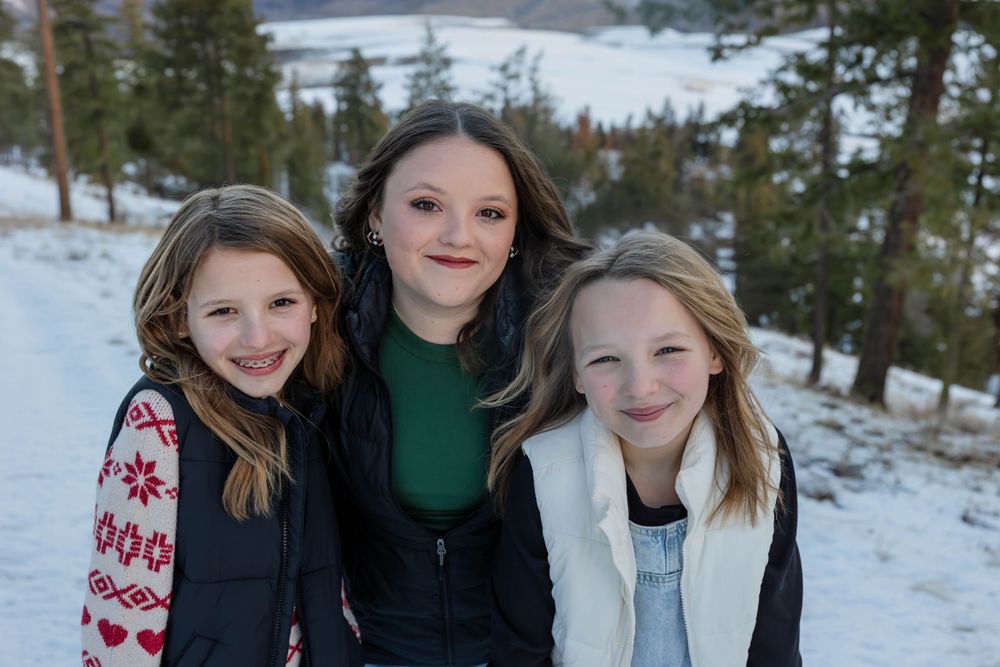 Winter portrait session on a snowy mountain overlooking a scenic lake view.