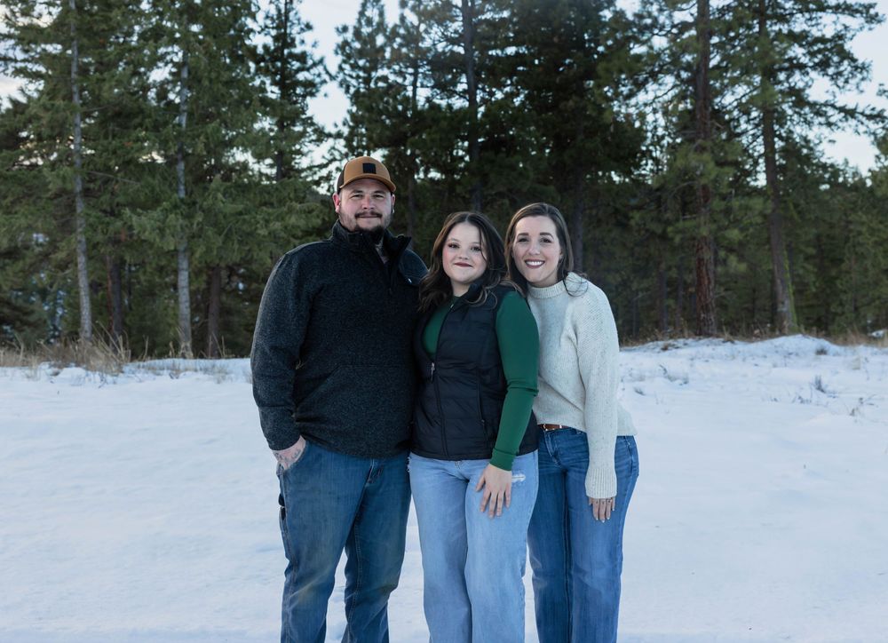 Group portrait in a snow-covered forest with pine trees.