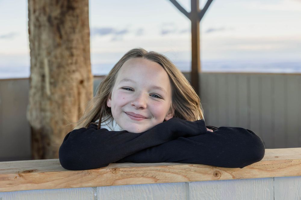 Casual portrait shots taken against wooden beams indoors.