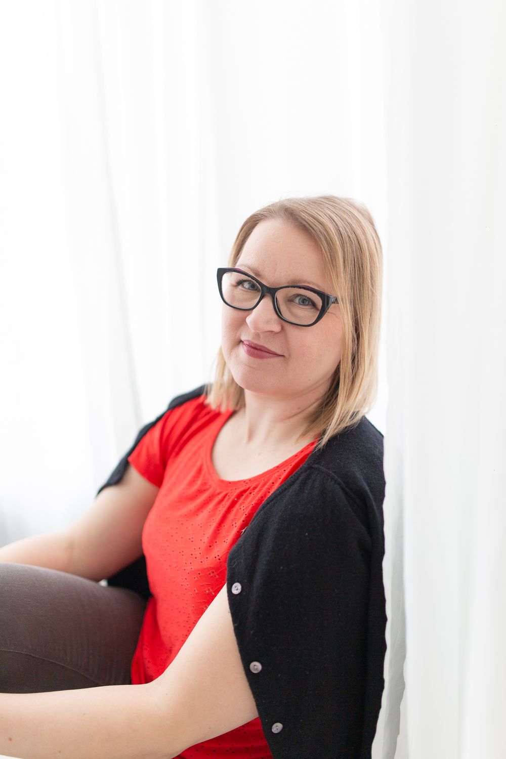 Kuva naisesta istumassa punainen paita päällä