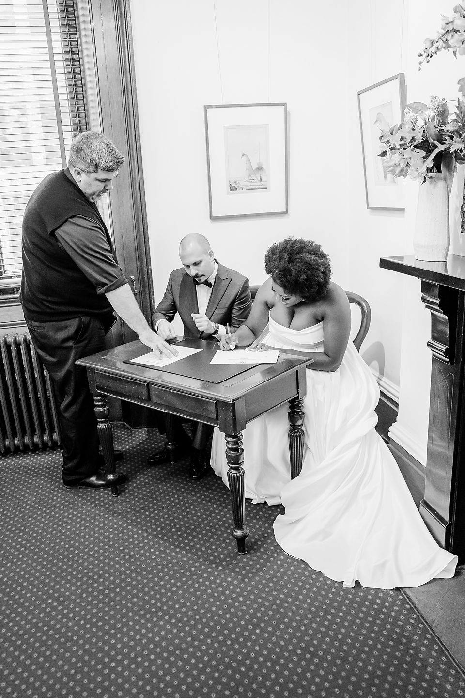 Black and white photo sequence showing a couple signing marriage documents at a desk with an officiant.