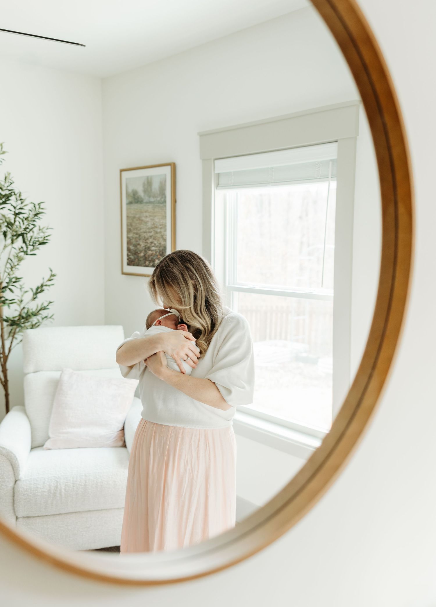 New parents admiring their newborn in a nursery, mother in blue dress, father in white shirt, sage green walls.
simple timeless natural