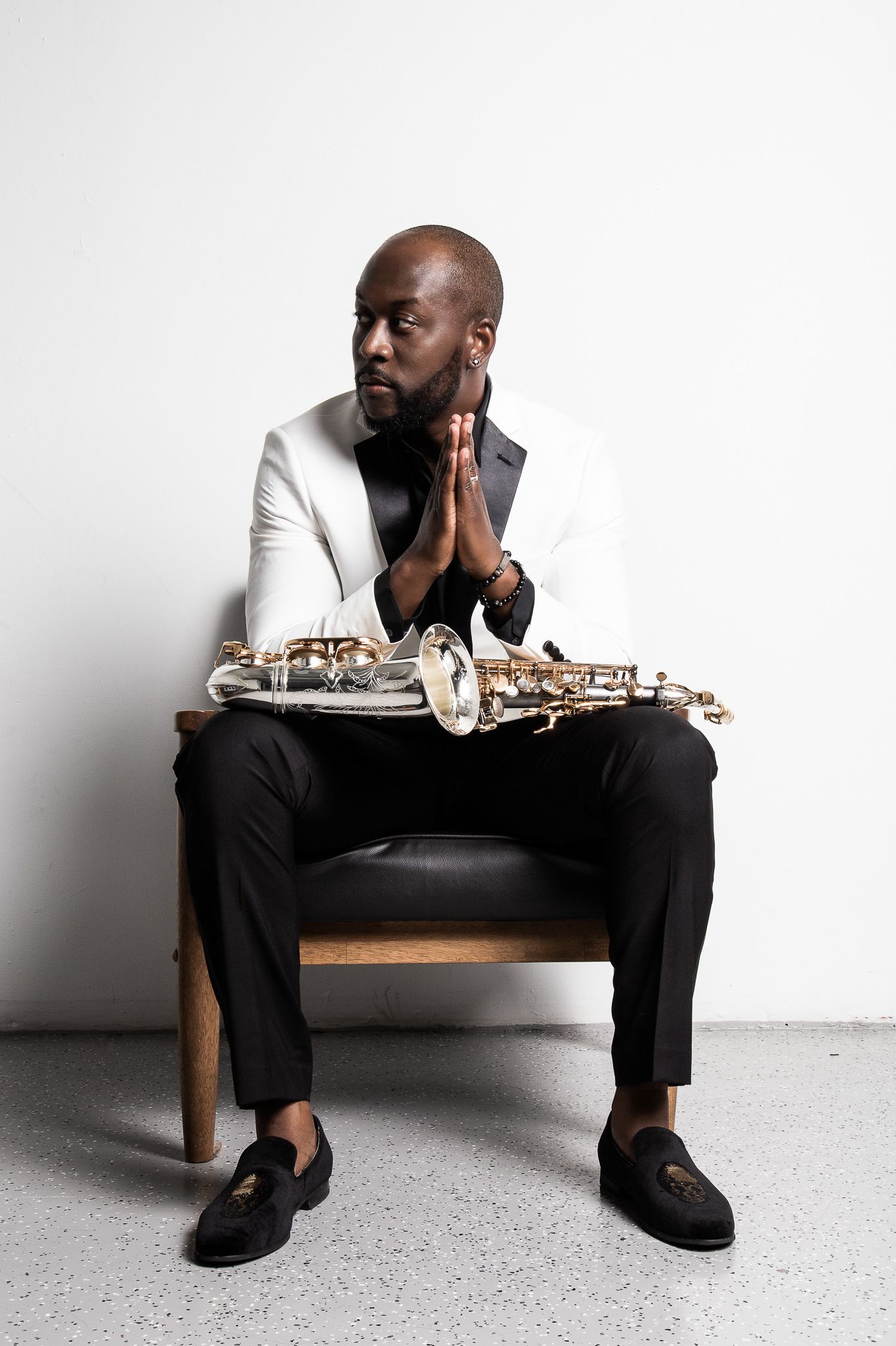 Minimalist portrait series with saxophone against white background showing contemplative poses.