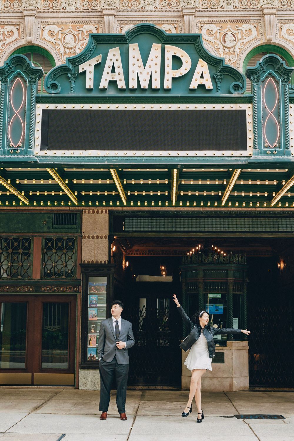 A couple poses beneath the historic Tampa Theatre marquee in downtown Tampa.