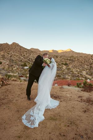 Couple embraces during sunset wedding photos with desert mountain backdrop.