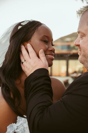 Tender moment captured between newlyweds during outdoor wedding celebration.