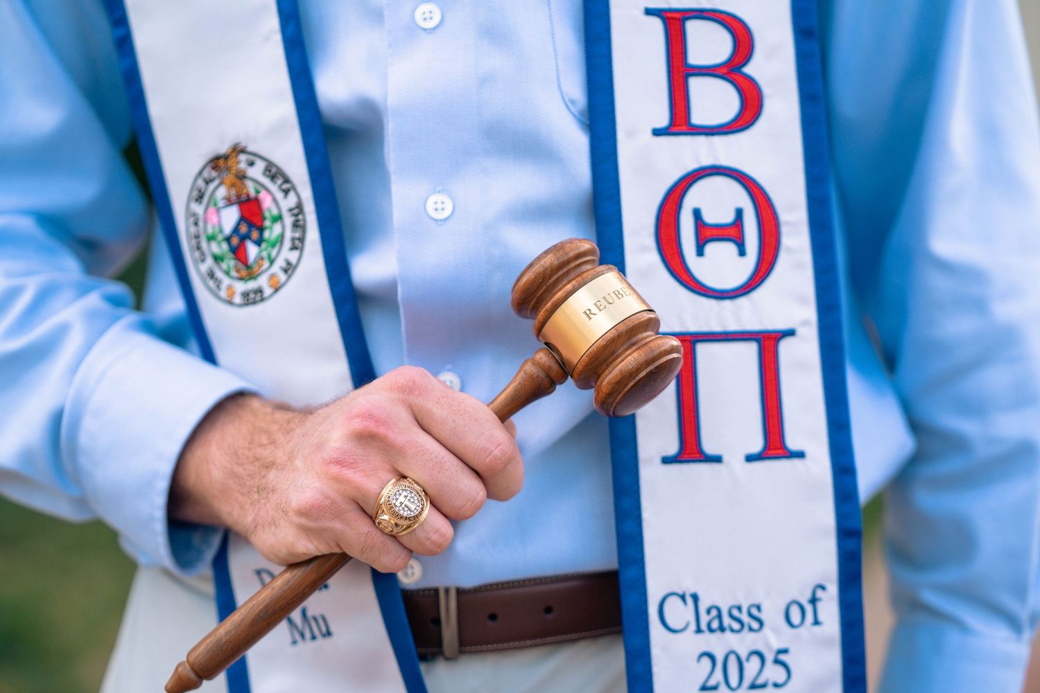 Close-up of graduation stole with Beta Theta Pi letters and ceremonial gavel.
