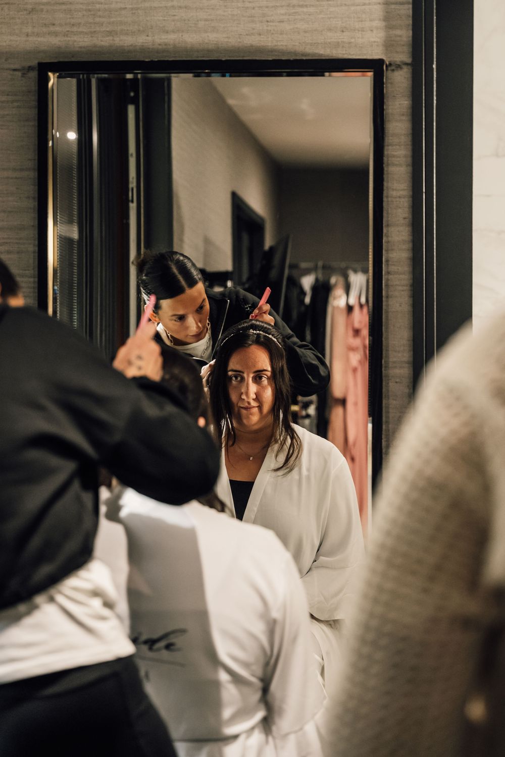 Wedding preparations in a modern indoor space with dark framed windows and natural lighting.
