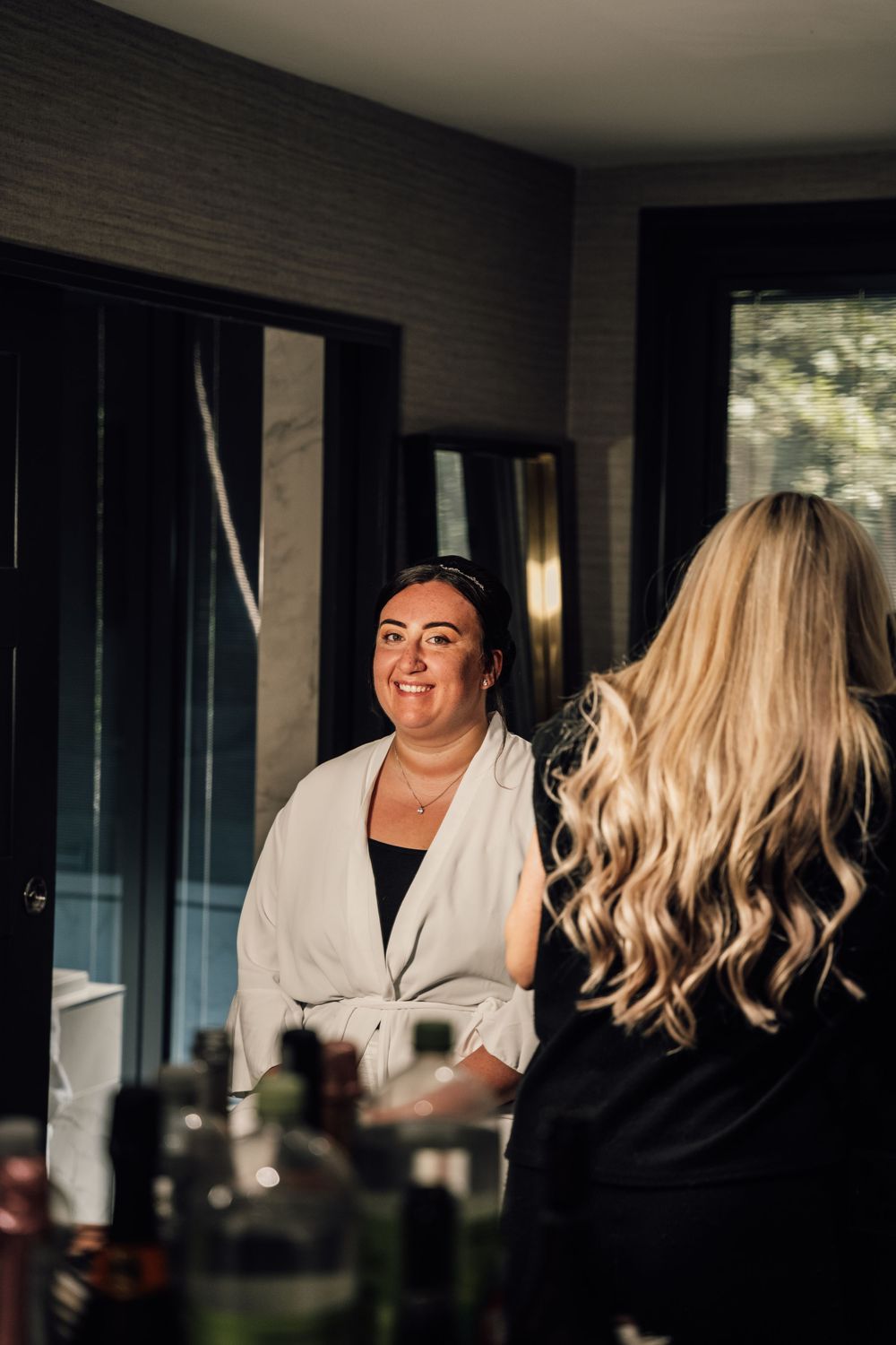 Wedding preparation scene in a naturally lit room with white robes and joyful moments.