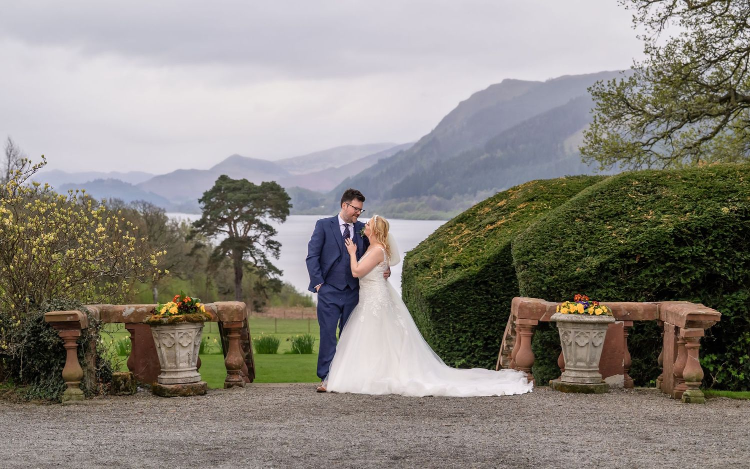 Bride and groom by steps down to lawn at Armathwaite Hall