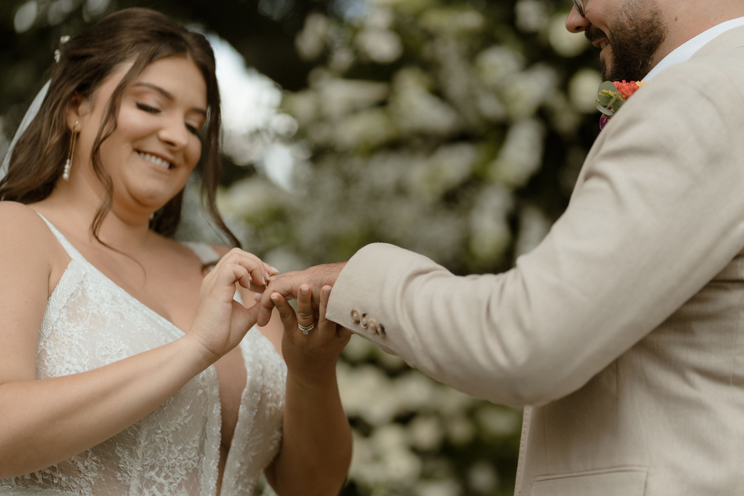 Playful moment during cake cutting ceremony with sunlit garden backdrop.