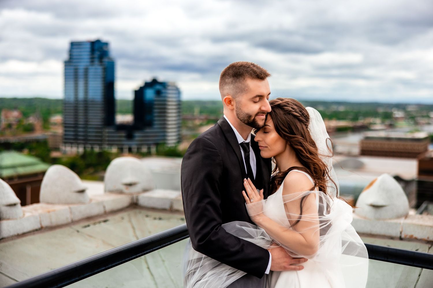 High-angle view of newlyweds in an elegant dress and suit lying on dark floor in modern hallway Grand Rapids Art Museum Michigan