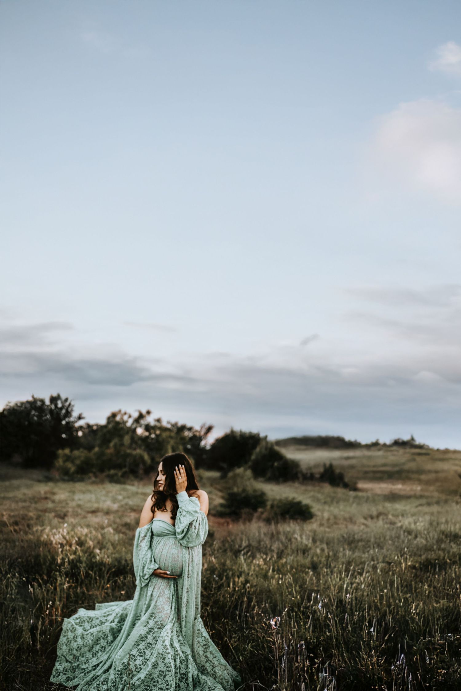 Pregnant mother in lace gown by water