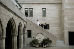 A stone archway corridor with white columns and stairs in an elegant historic building interior.