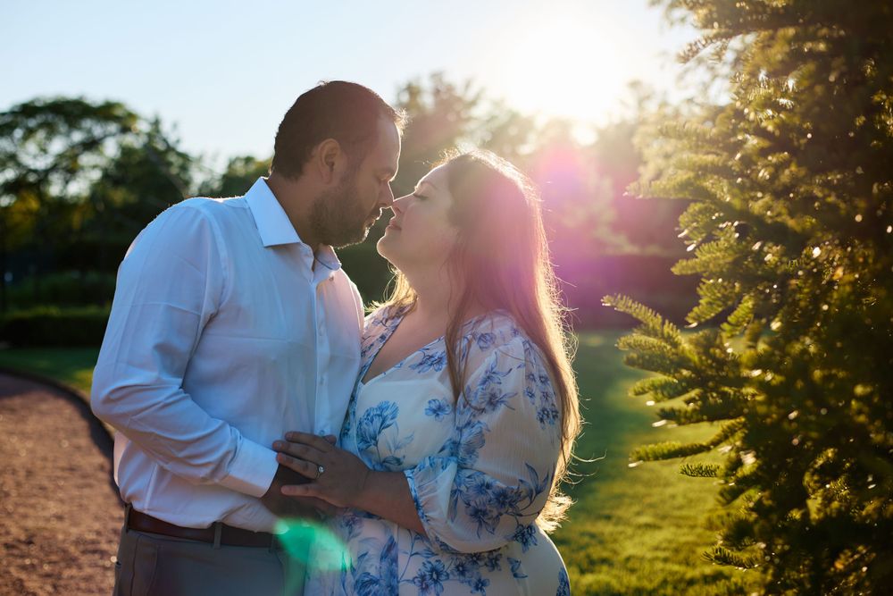 A romantic sunset portrait with golden sunlight streaming through trees.