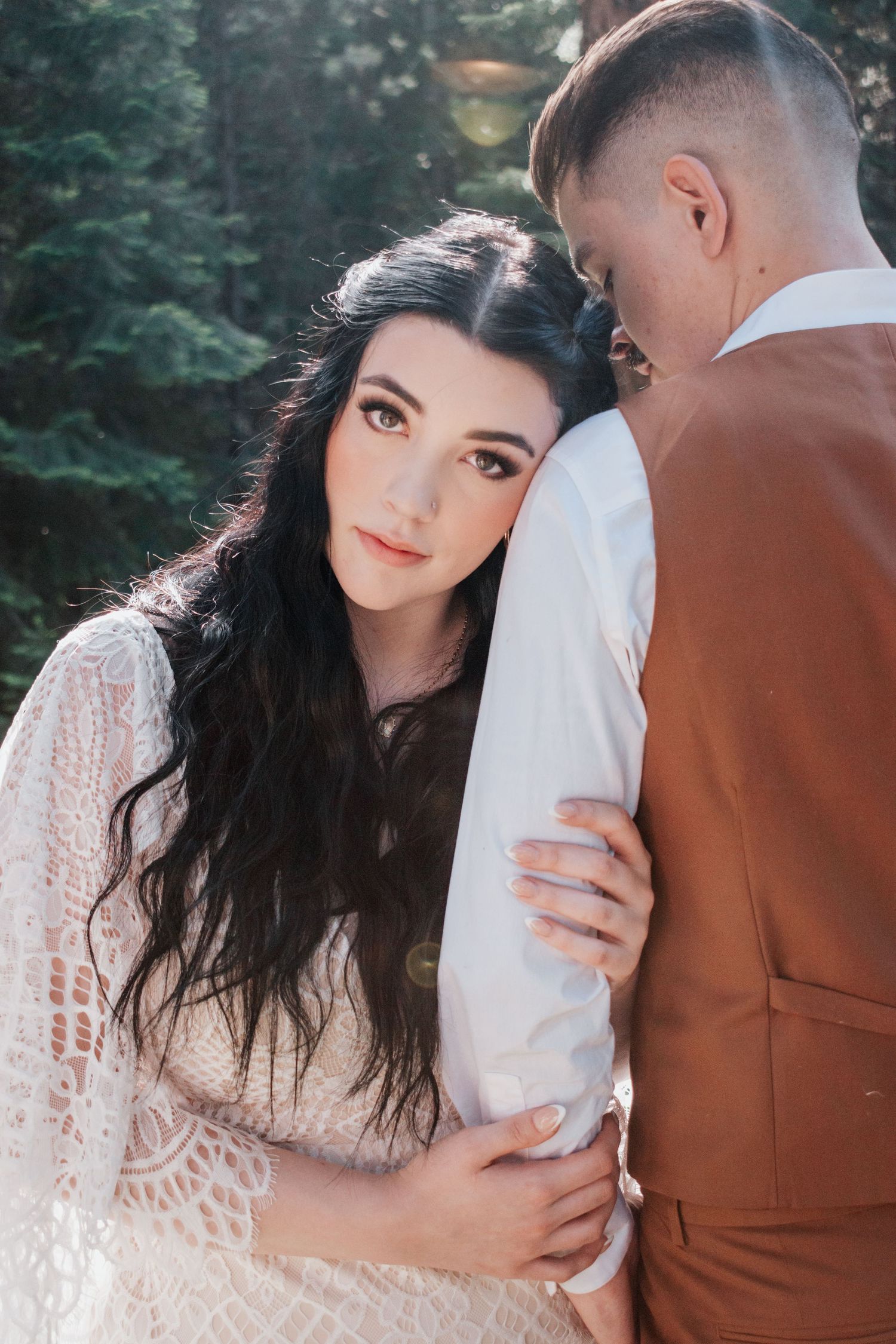 A close-up portrait of a bride-to-be leaning into her fiancé in a serene woodland setting, capturing quiet connection and soft natural light