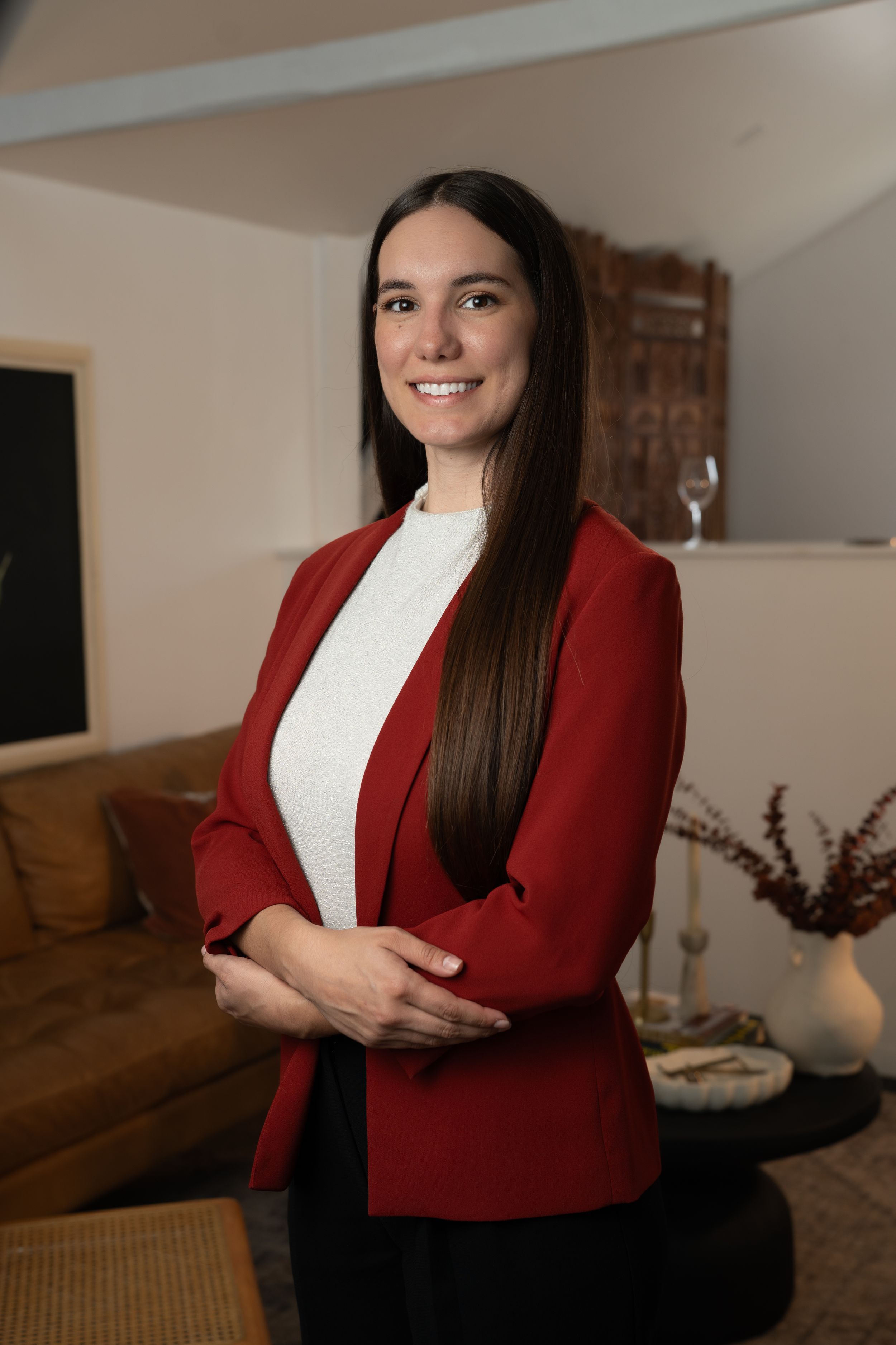 Professional portrait series showing person in red blazer and white top posing against neutral home interior background.