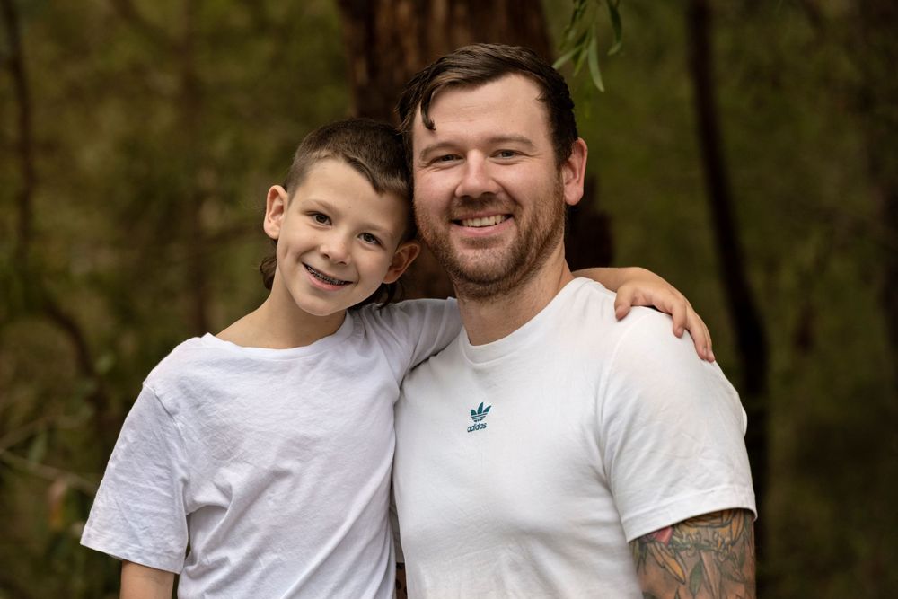 Father and son during family portrait session in a natural wooded setting.