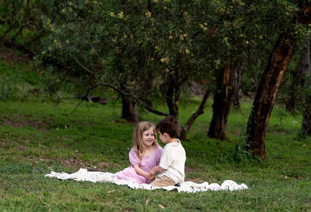 Relaxed family portraits taken outdoors with natural woodland backdrop.