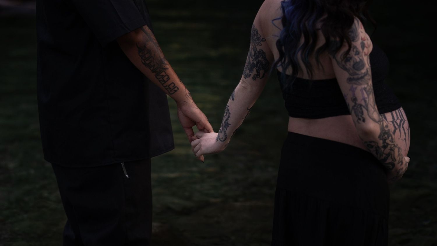 Couple holding hands and spinning on beach at sunset.