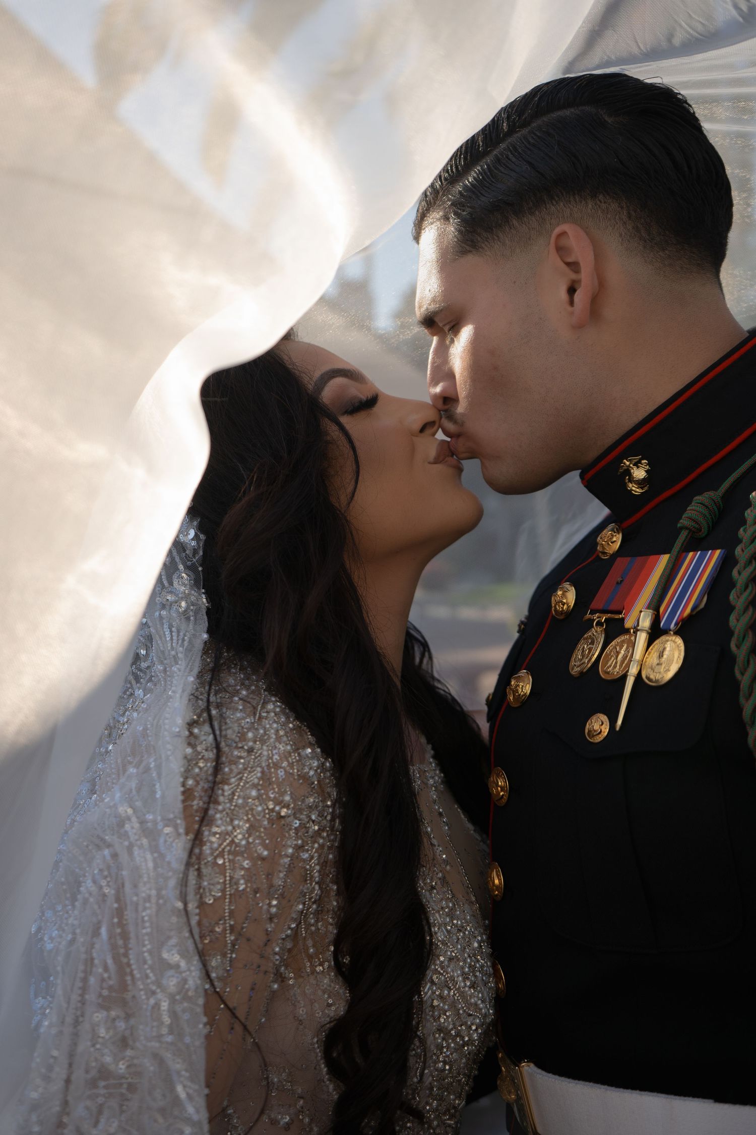 A romantic wedding portrait sequence showing a bride in a sparkling gown and groom in military dress sharing intimate moments.