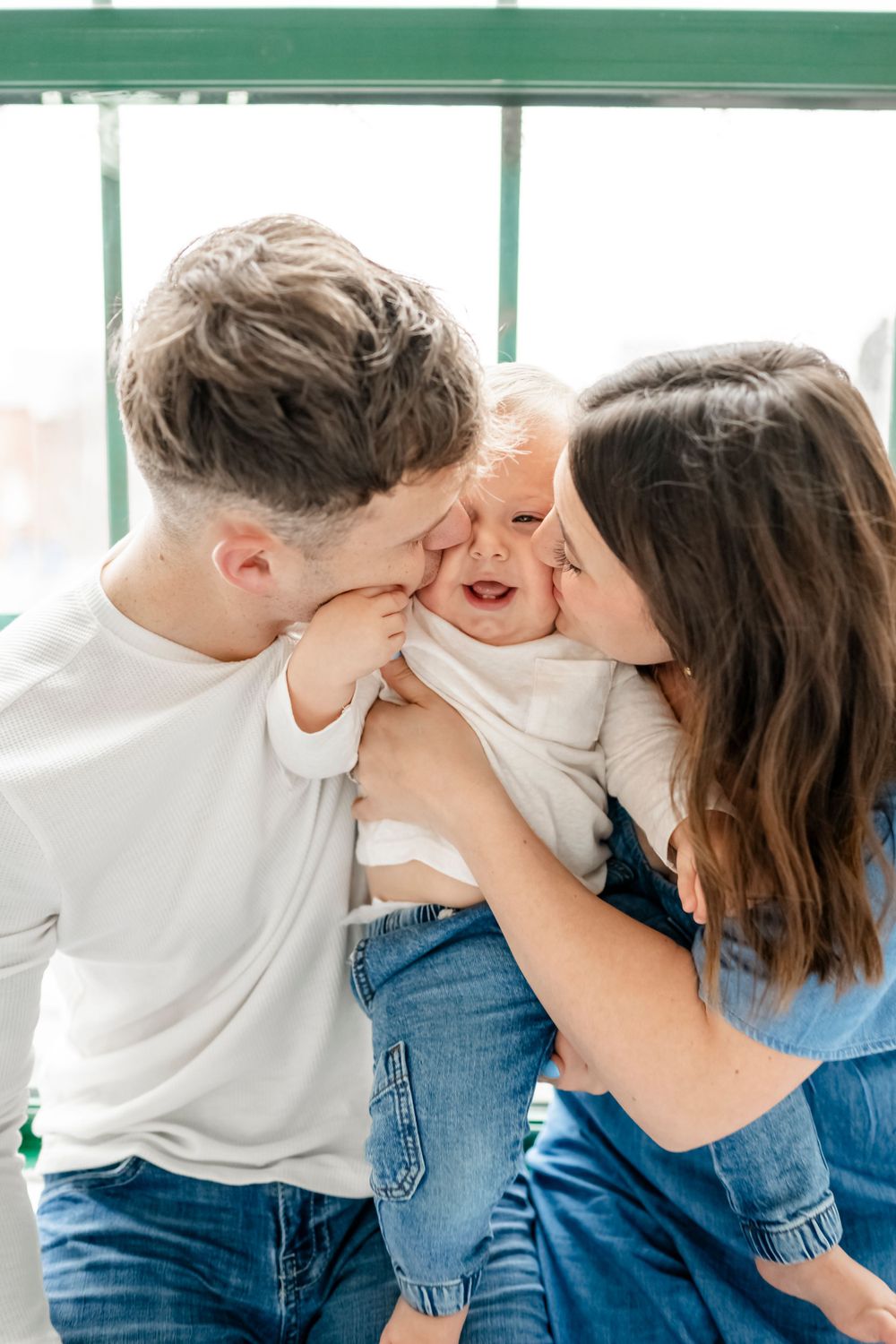 Intimate family studio portraits with soft lighting and denim outfits.