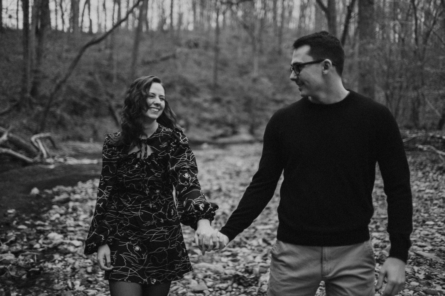 Playful couple enjoying a winter photoshoot in a snowy forest setting.