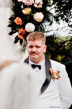 Wedding ceremony setup with floral arch featuring pink and white blooms.