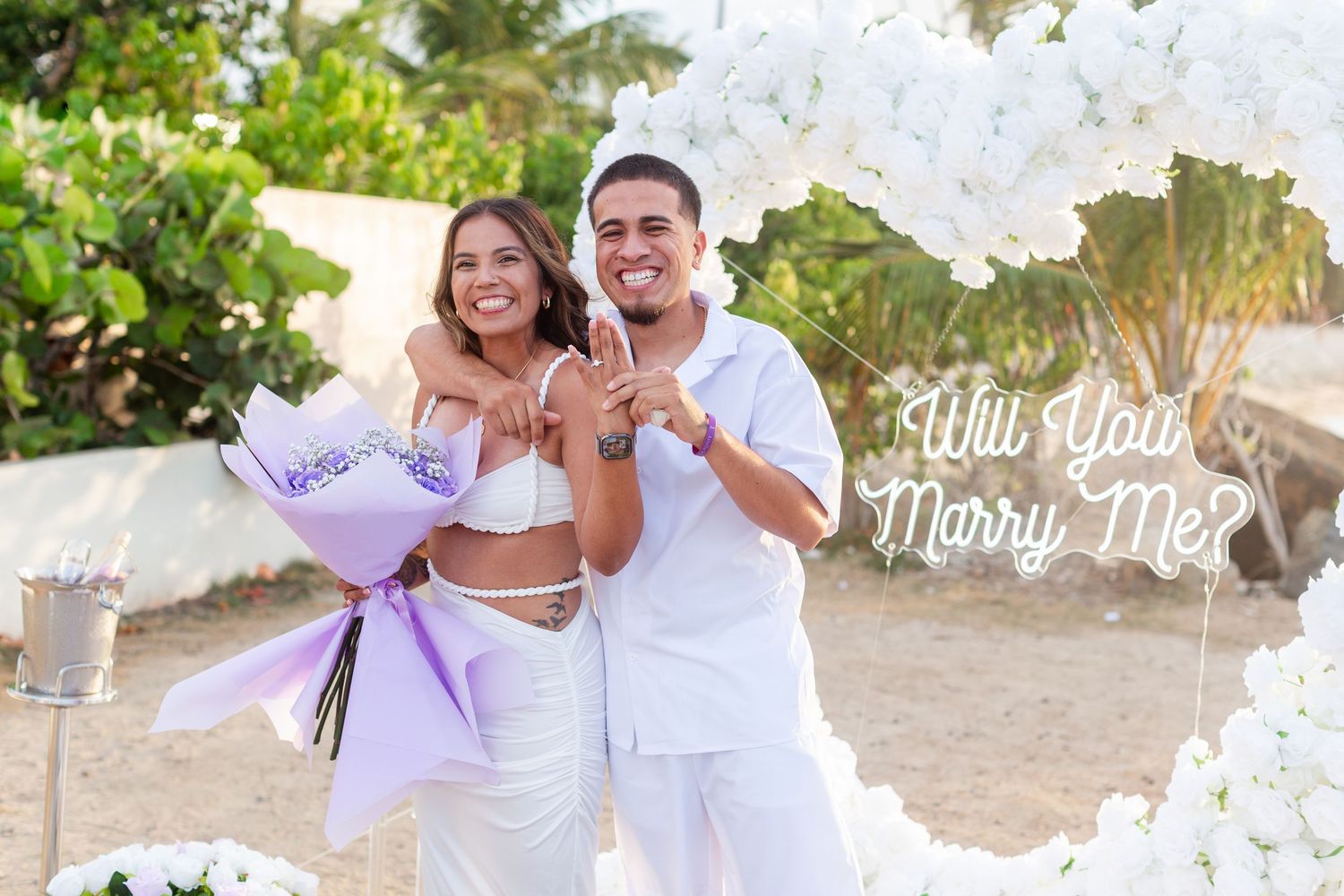 Marriage proposal. Man, woman, and decorative setup with white flower heart overlooking the ocean in Río Grande, Puerto Rico.