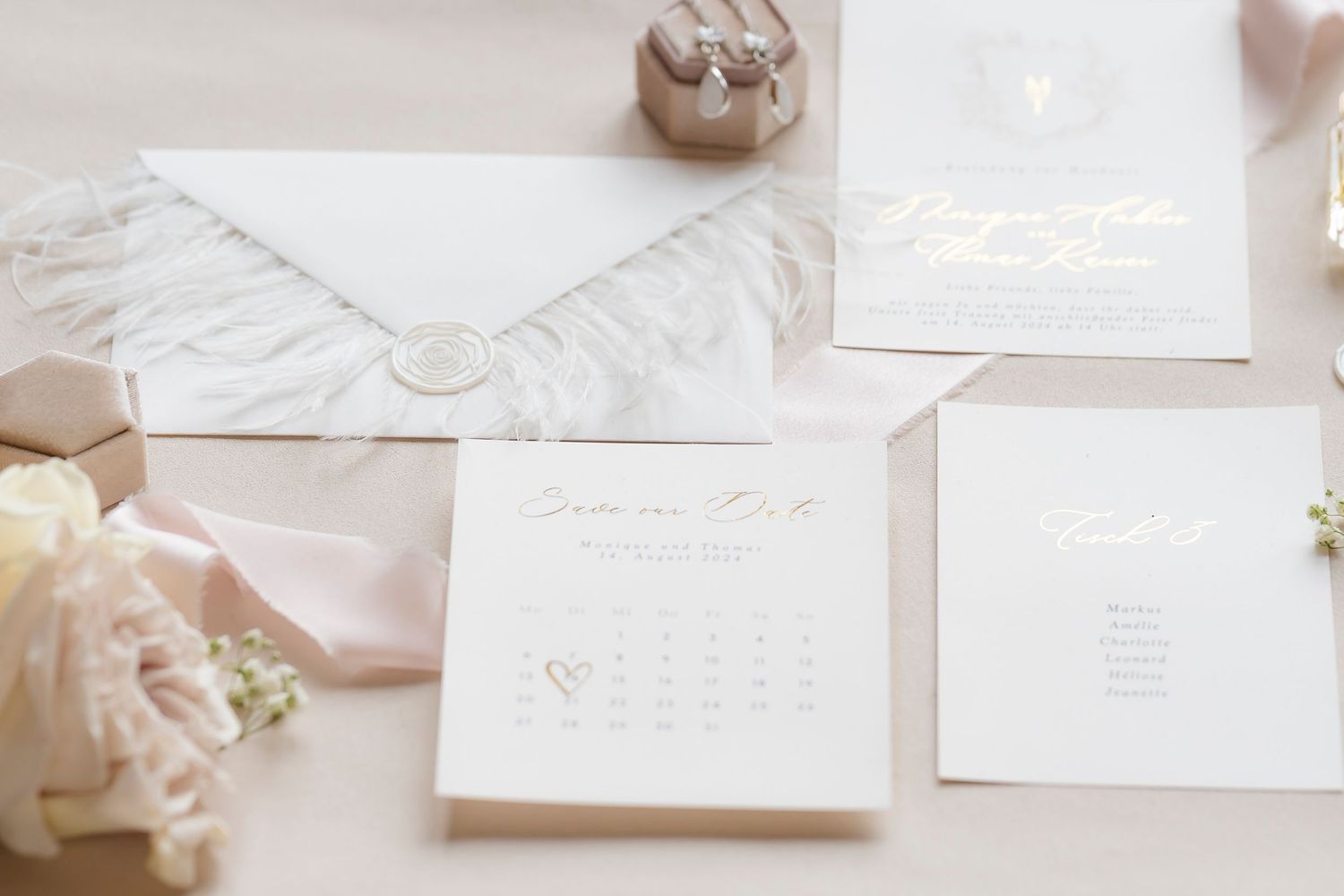 Elegant wedding stationery suite with gold foil save the date calendar card, envelope with wax seal, and floral accents.