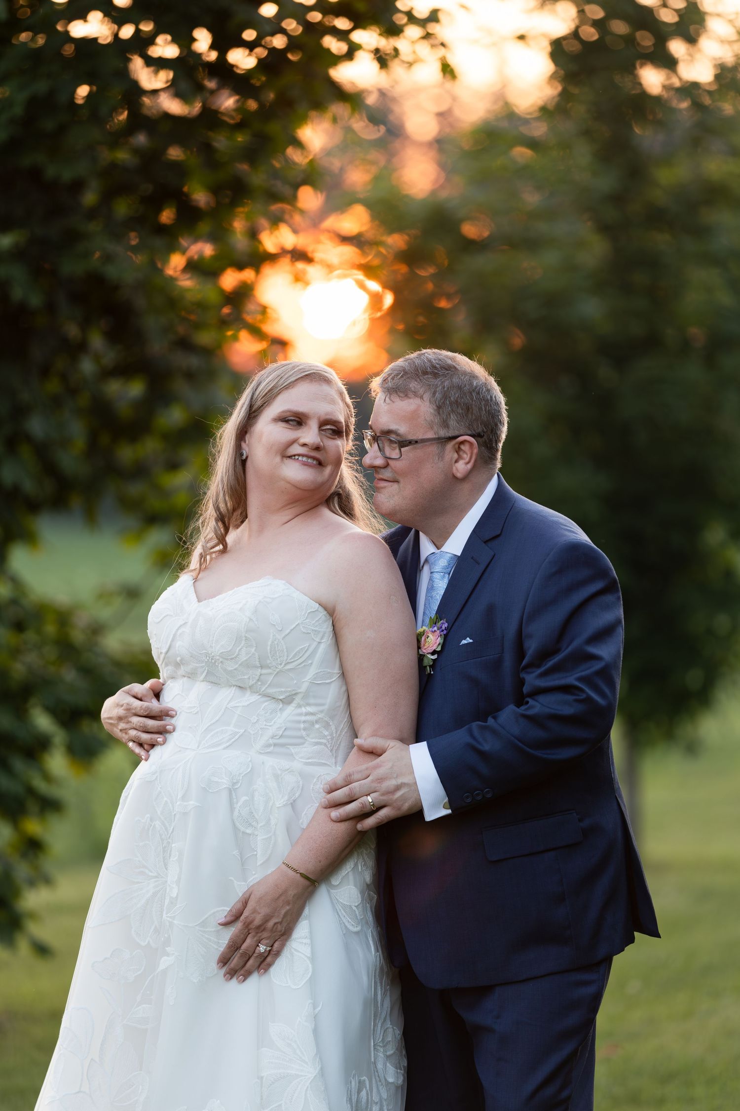 Bride and groom embrace outdoors at golden sunset at barn swallow fields in guelph, ontario.