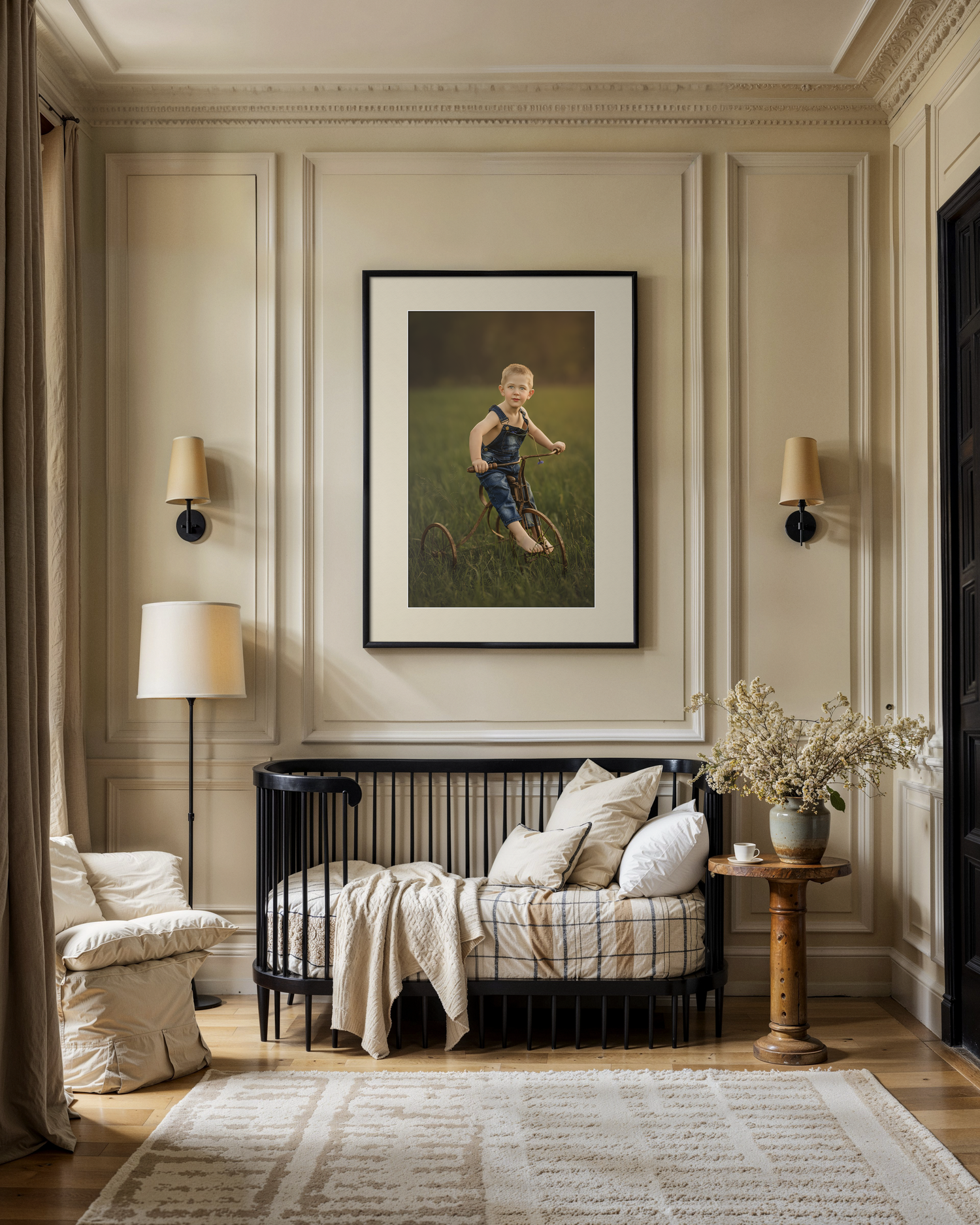 Elegant nursery with black crib, framed child portrait, wall sconces, cream armchair, and neutral decor on herringbone floor.
