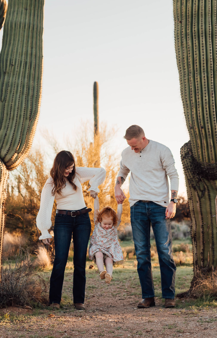 Mother and father hold daughter between them for family photoshoot in Tucson, Arizona.