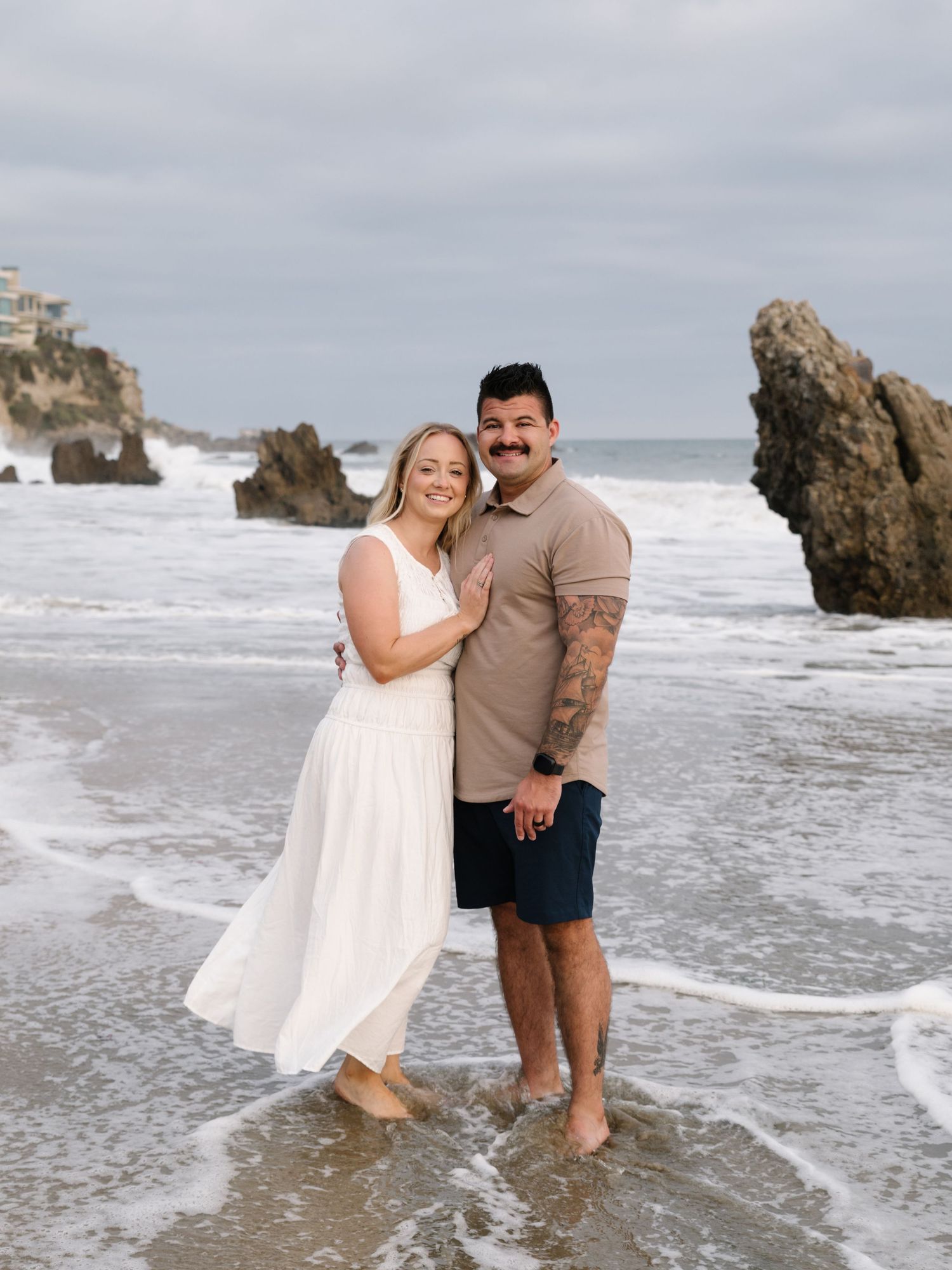 Couple standing together in the ocean during their Newport Beach family photography session.