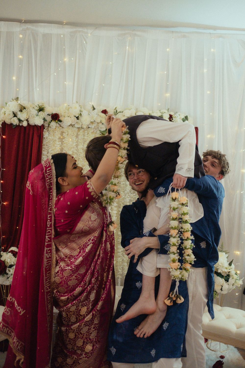 Bride placing garland over groom at a wedding ceremony.