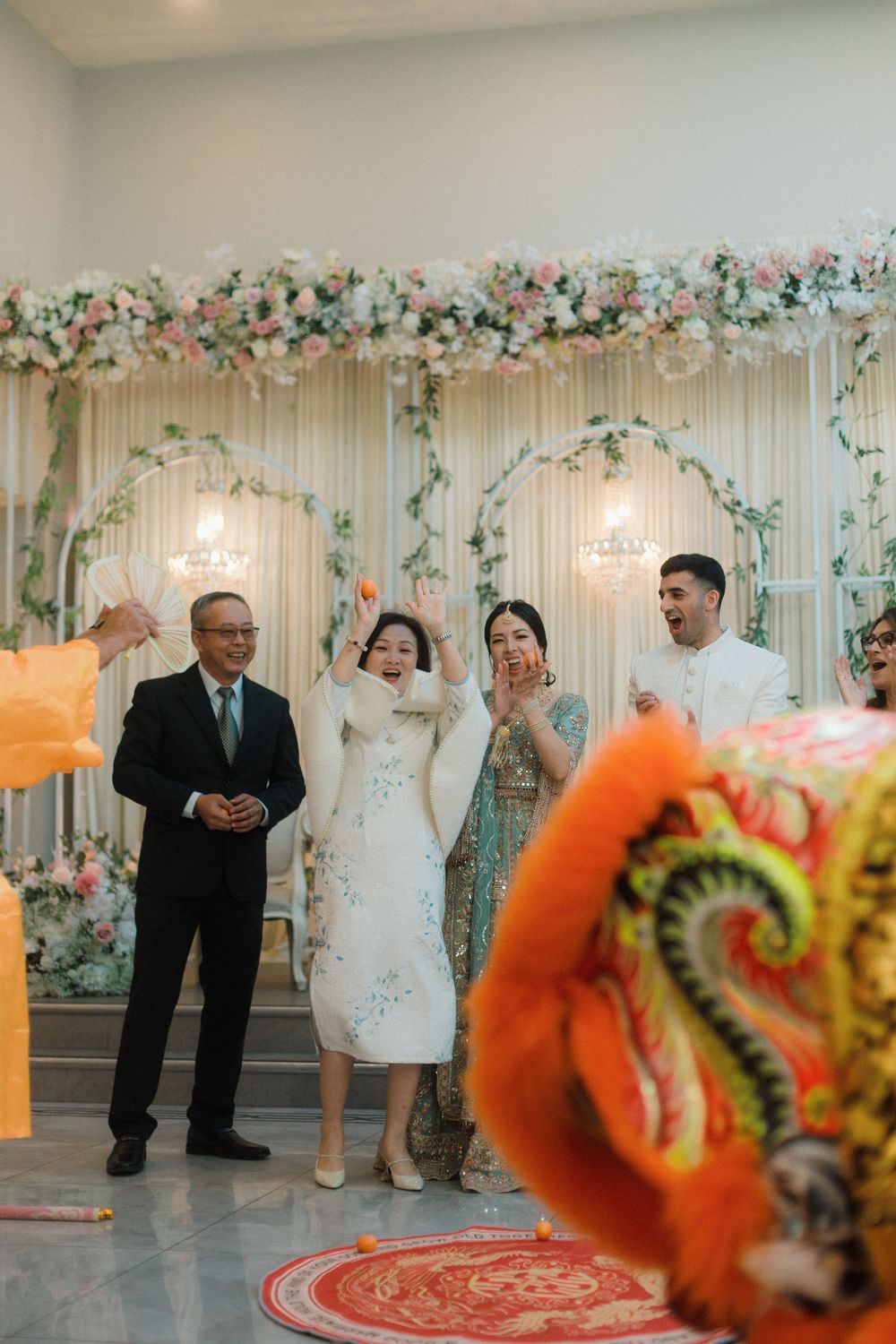 Mum catching a ball during the Chinese dragon ceremony at a fusion wedding at Walton View hotel. UK