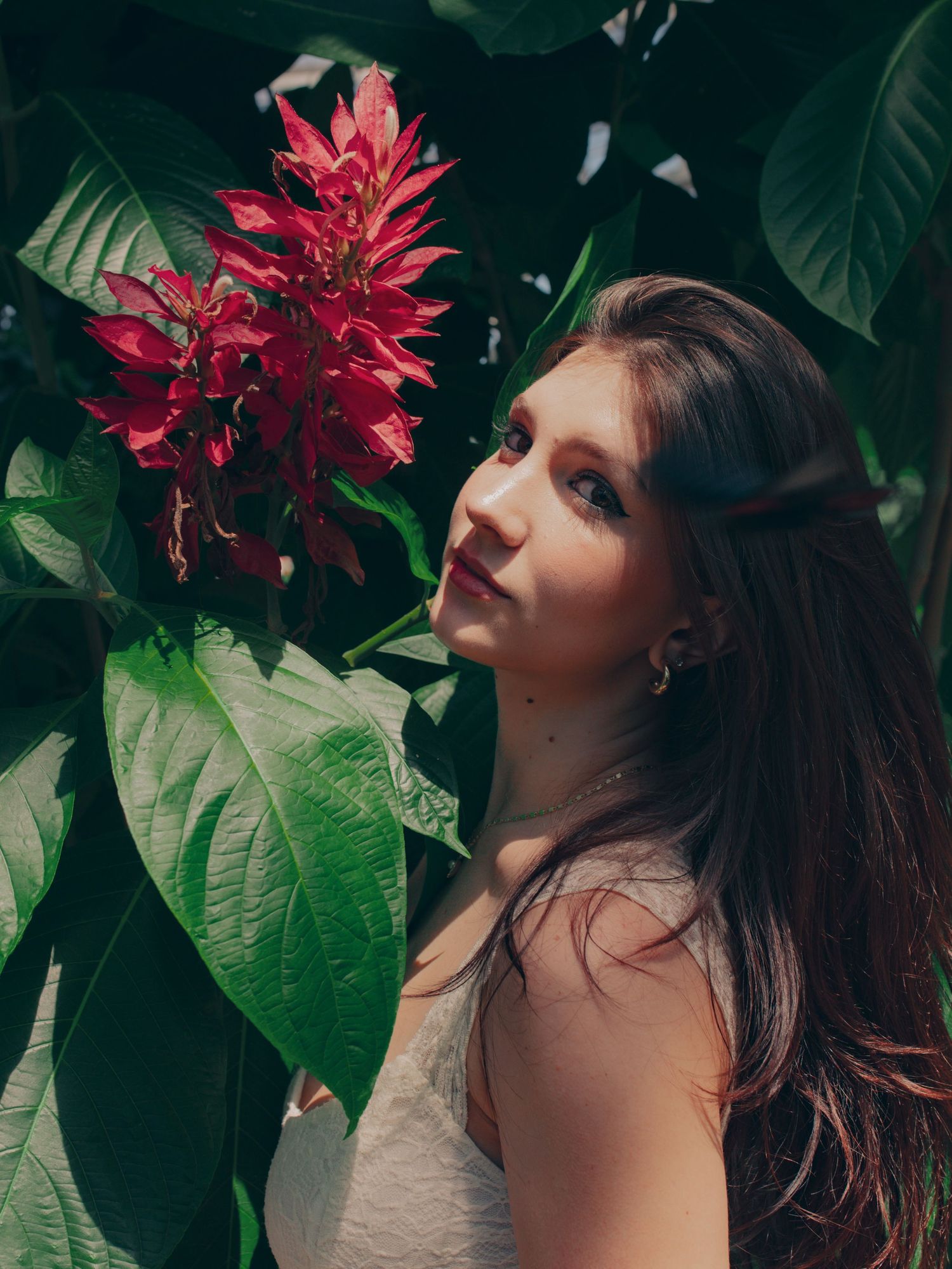 Creative portrait of a woman surrounded by vibrant red flowers
