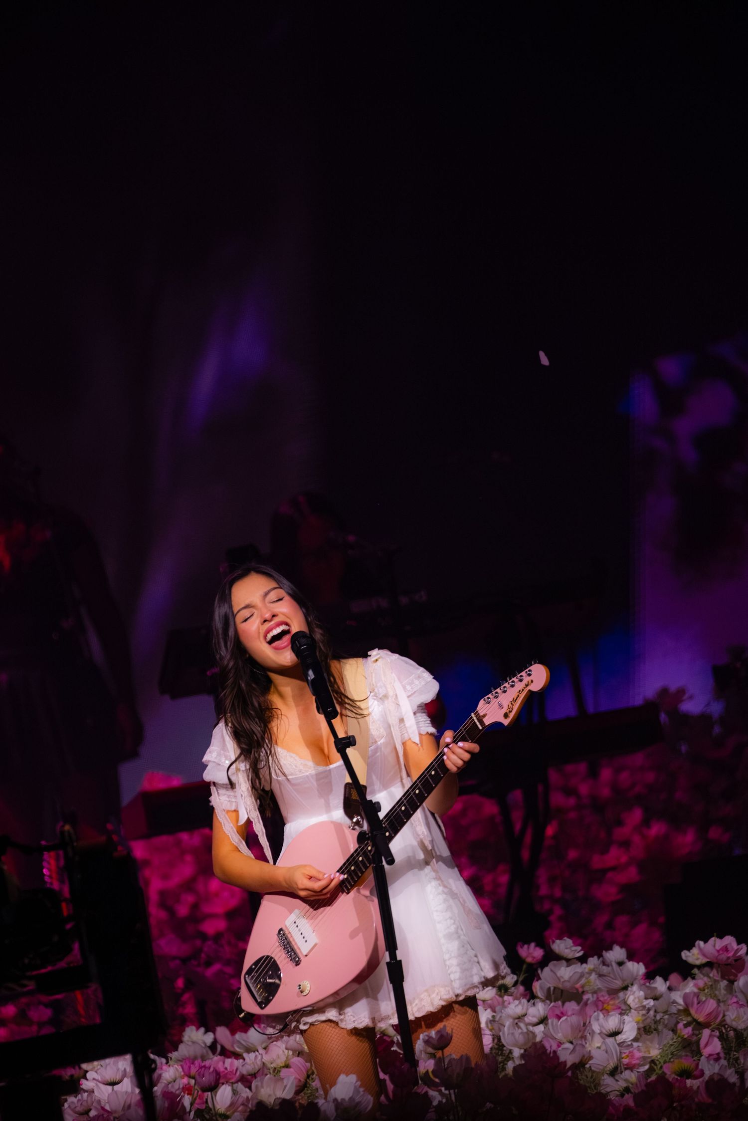 Olivia Rodrigo sings and plays a pink electric guitar during opening night of the Unraveled Tour at PeoplesBank Arena in Hartford, CT