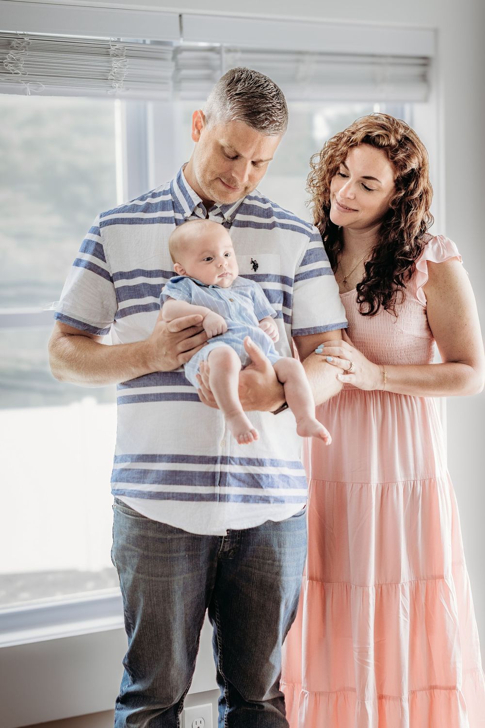 Mom and dad holding their baby during a relaxed South Jersey newborn photography session.