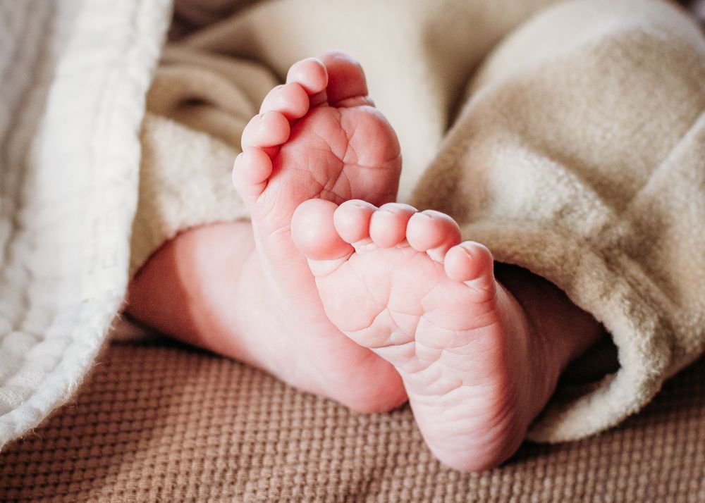 Close-up of newborn baby’s tiny feet during an in-home newborn photography session