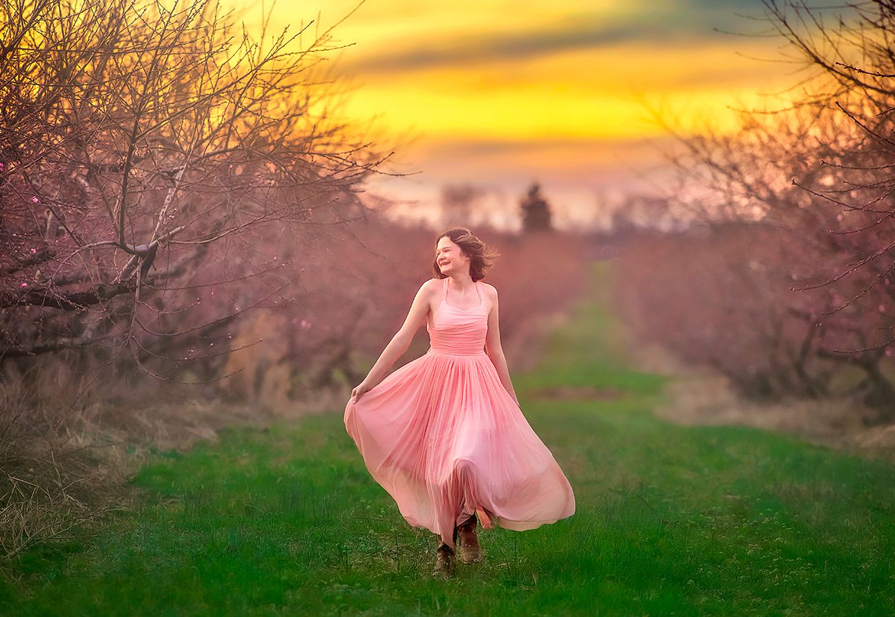 girl running in a peach orchard near Bridgeton New Jersey for a portrait session