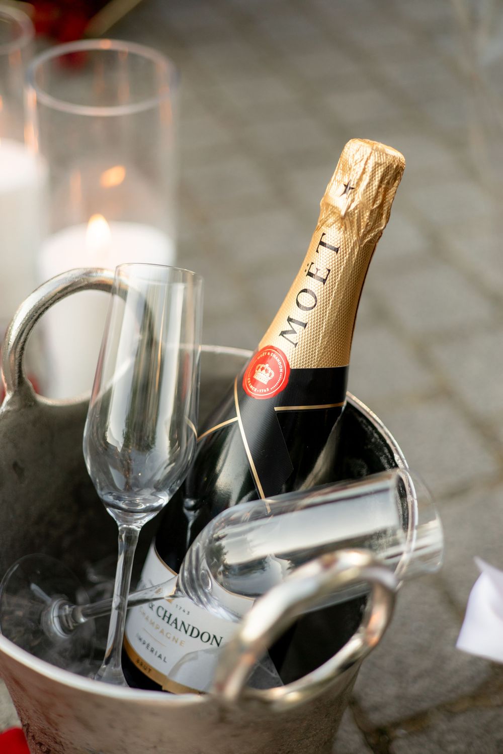 Moet Chandon champagne bottle chilling in ice bucket with crystal flutes for romantic celebration.