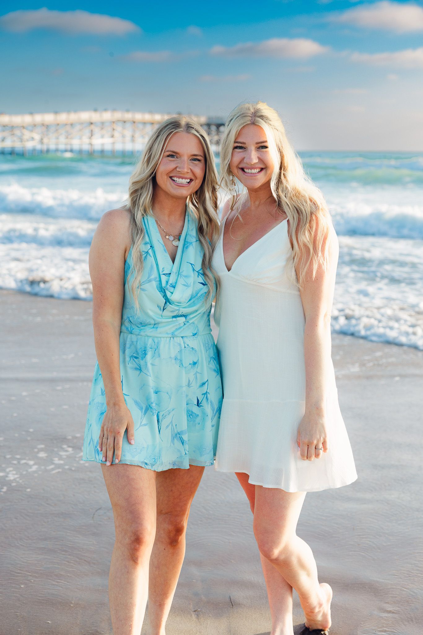 San Diego beach portraits of two women posing at Crystal Pier in Pacific Beach with ocean waves in the background.