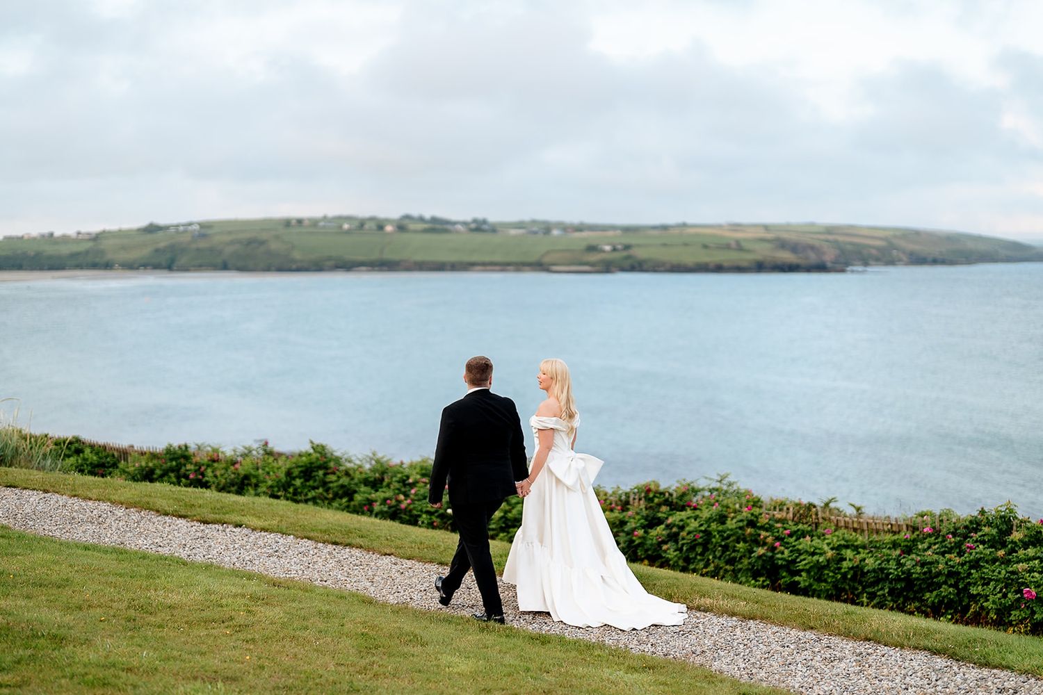 A lakeside wedding sequence shows silhouettes of a bride and groom walking along the shoreline with scenic water views.
