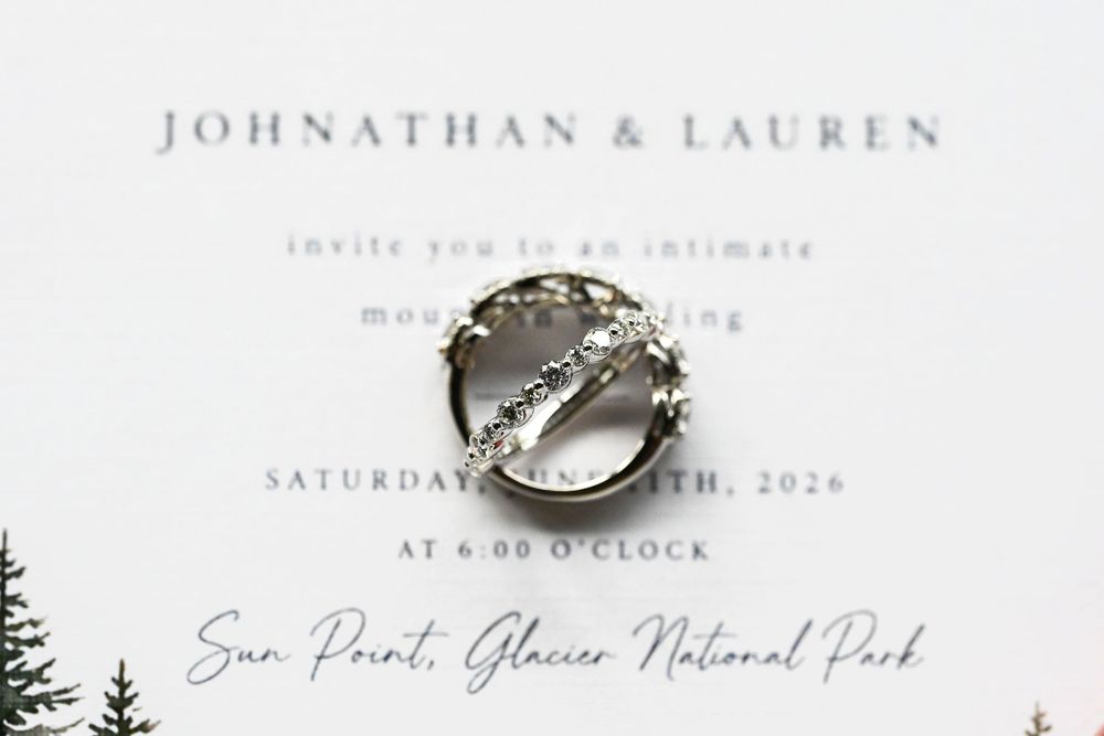 Wedding invitation for Johnathan & Lauren at Sun Point, Glacier National Park, featuring diamond rings on elegant white stationery.