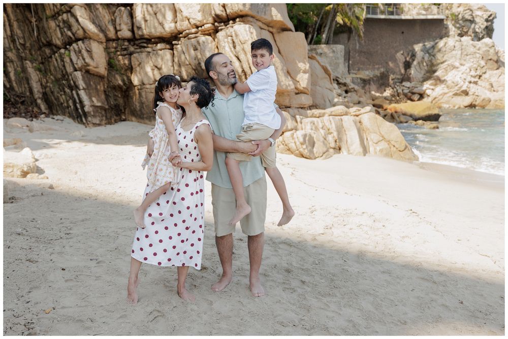 Hyatt Ziva Puerto Vallarta Family Photographer capturing a family embracing on a sandy beach with during Beach Family Photography.