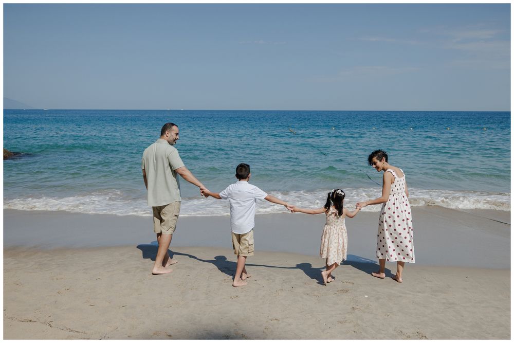 Hyatt Ziva Puerto Vallarta Family Photographer capturing a family holding hands by the ocean during Sunset Family Photos.