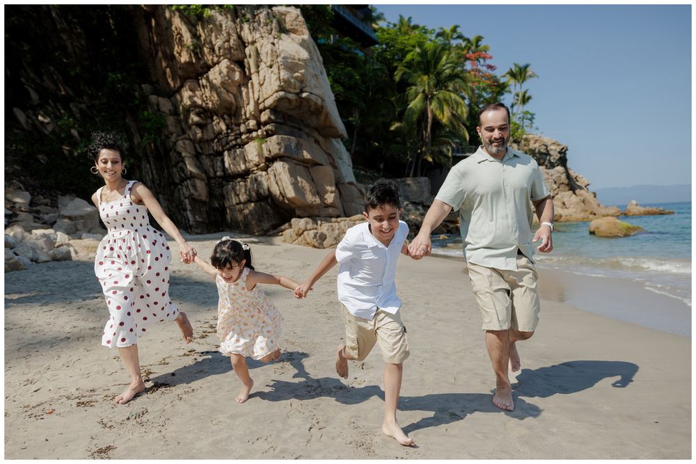 Hyatt Ziva Puerto Vallarta Family Photographer capturing a family running together on the beach during Family Photo Session.