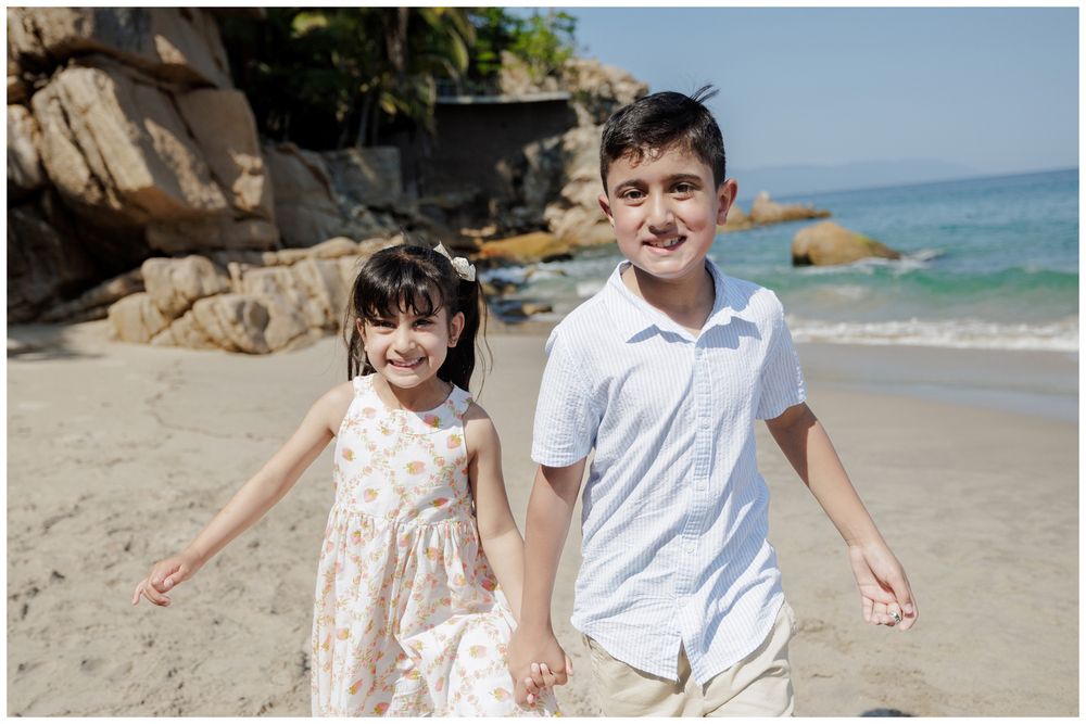 Hyatt Ziva Puerto Vallarta Family Photographer capturing siblings running hand in hand during Beach Family Photos.